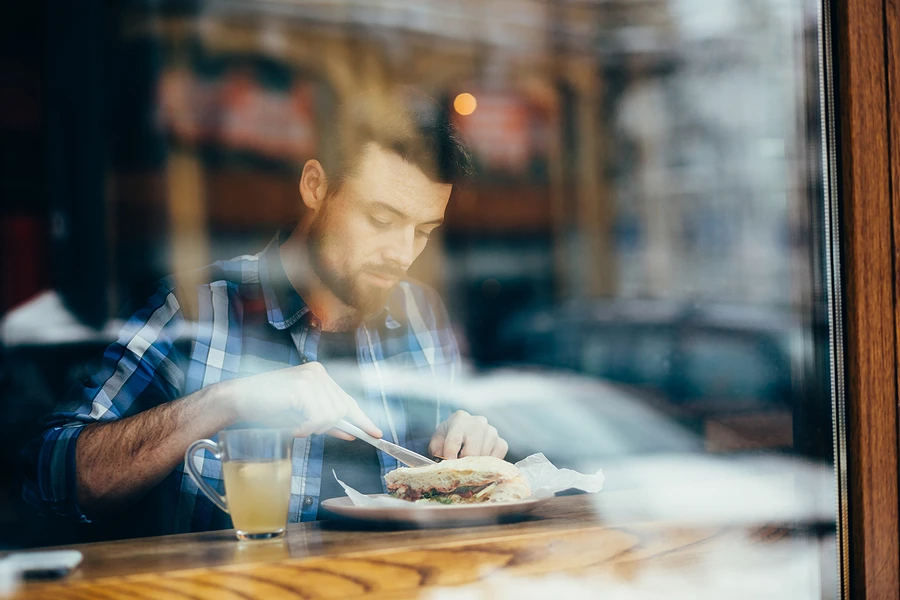 a man eating sandwich from restaurant franchise