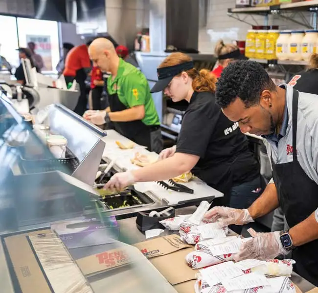 preparing sub orders in a Penn Station Restaurant